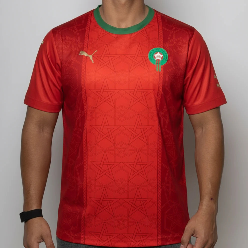 Red sports jersey with star pattern and logo on a plain background