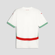 White dress with green and red accents on a light gray background