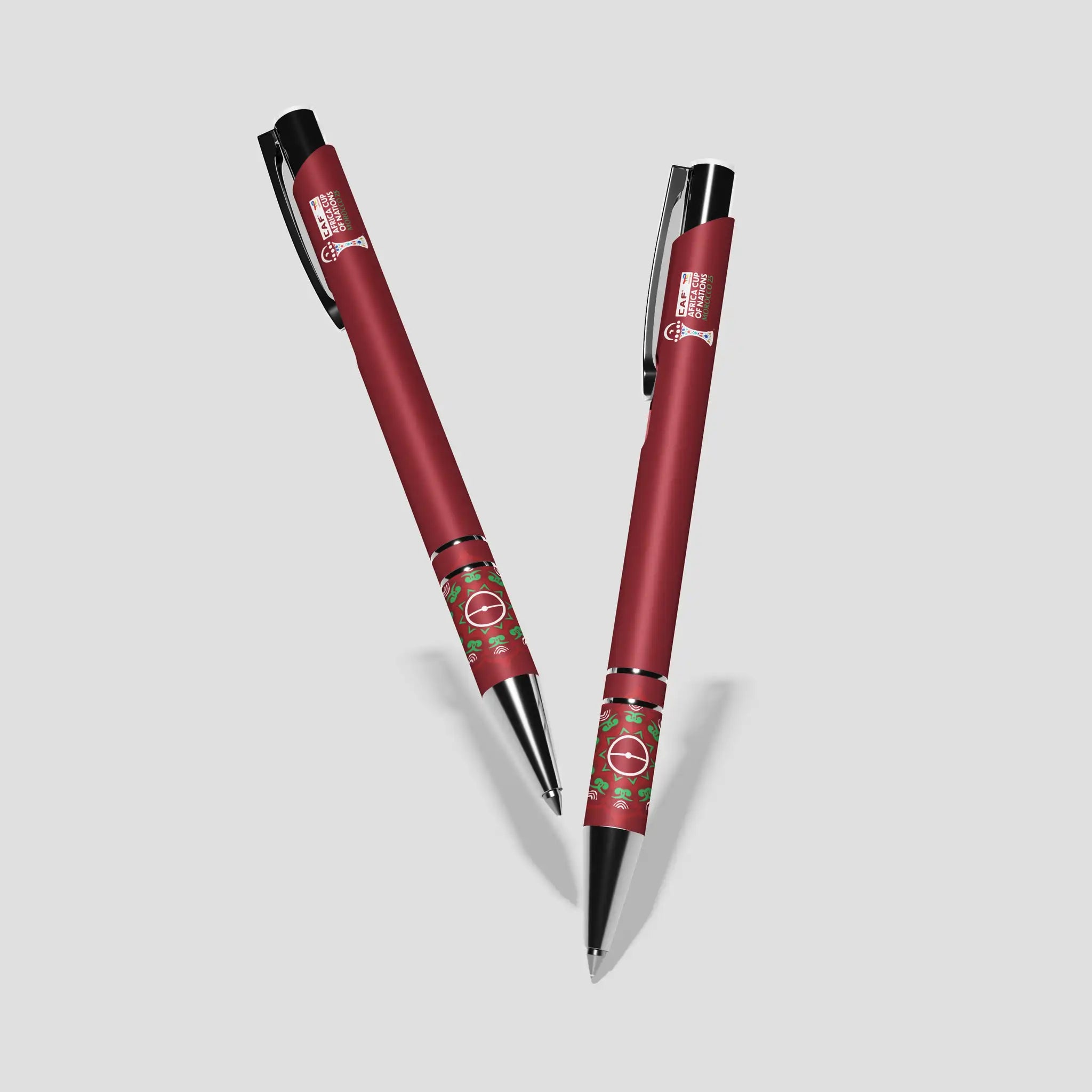 Two red pens with black accents on a light gray background